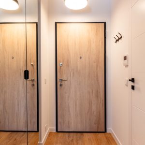 Contemporary hall with wooden doors and pendant lights.